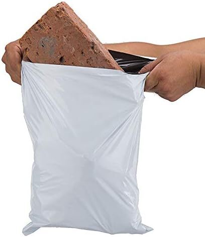 White trash bag being filled with brick and concrete pieces.