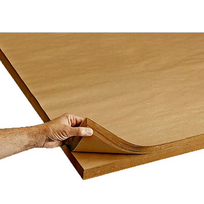 A person's hand holding a stack of brown kraft paper sheets.