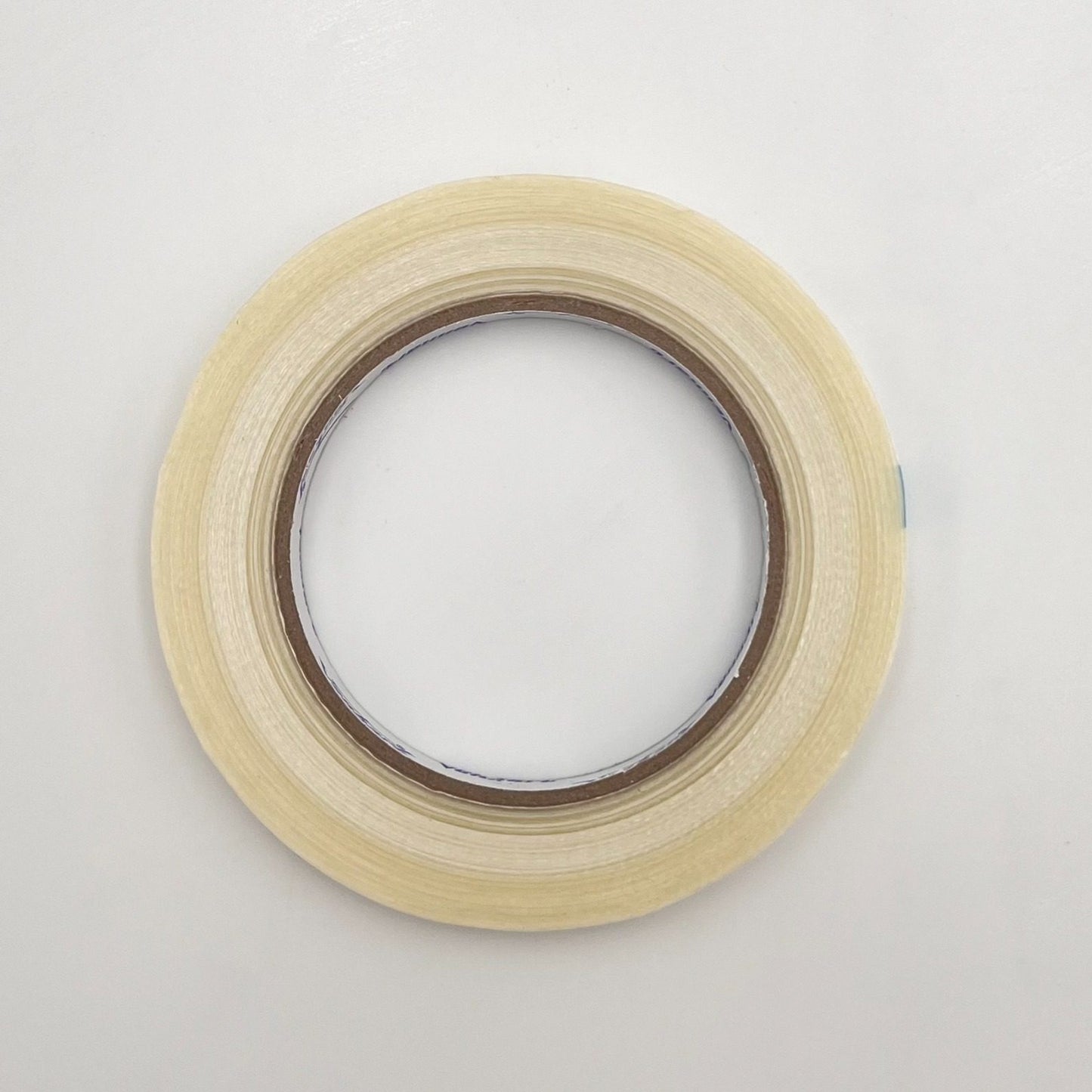 A roll of light beige masking tape on a plain white background.