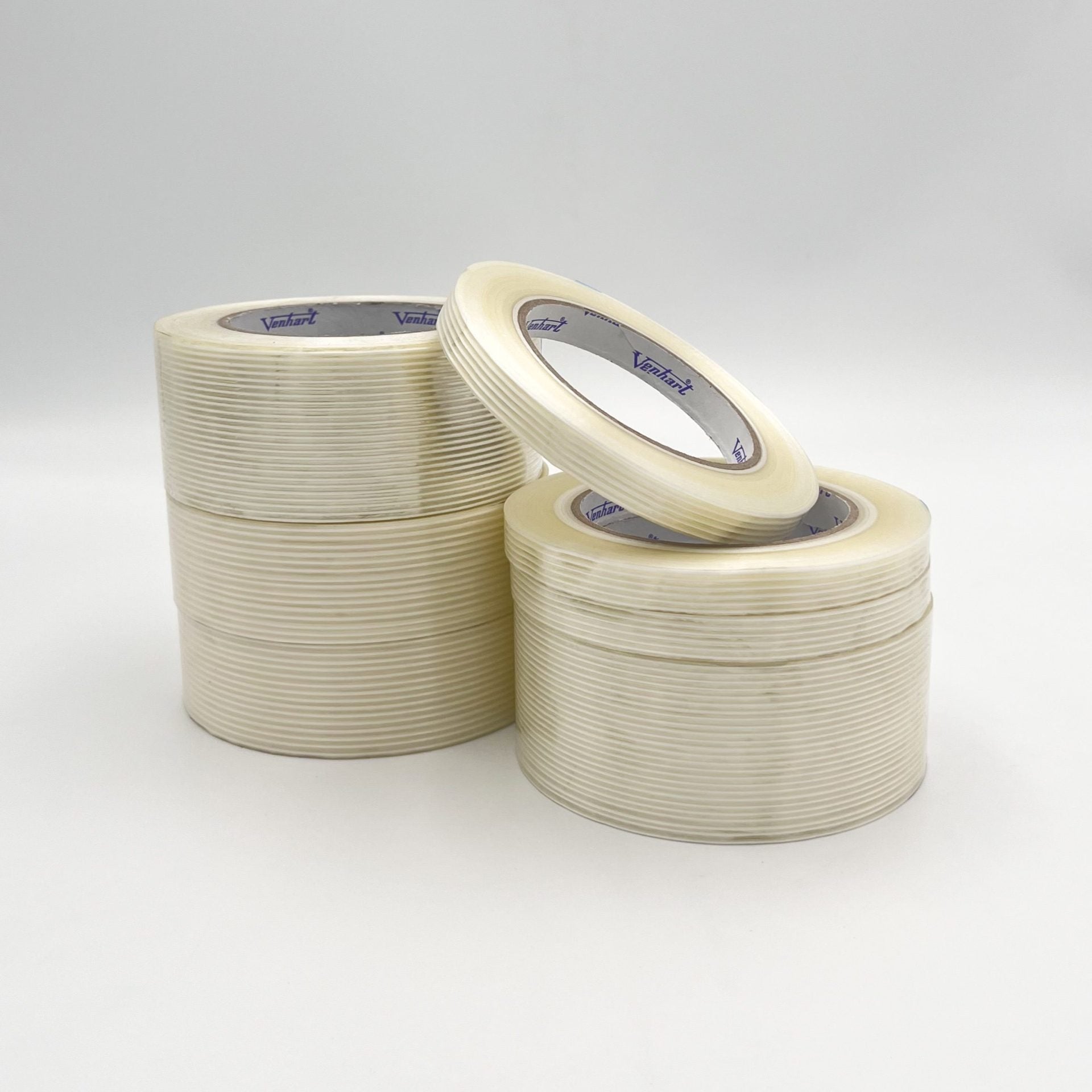 Three rolls of clear adhesive tape stacked on a light gray background.