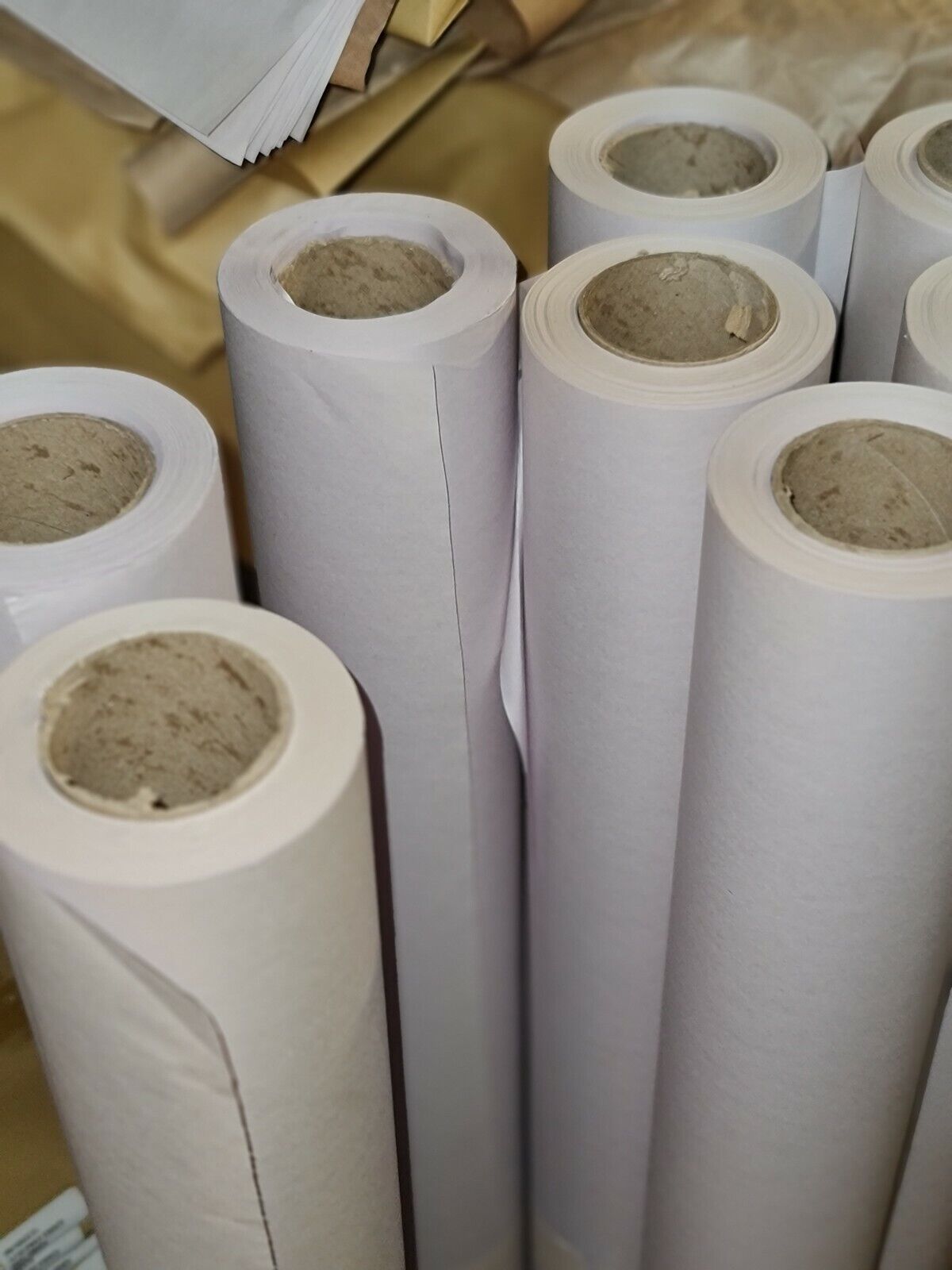 Rolls of white butcher's paper stored in a warehouse setting.