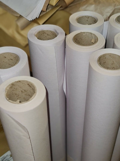 Rolls of white butcher's paper stored in a warehouse setting.