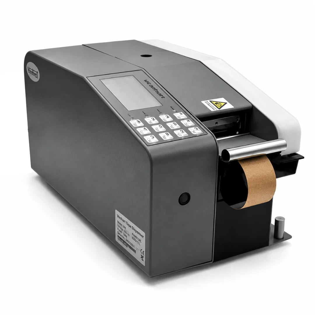 A black and white industrial barcode scanner with a digital display screen and numeric keypad, shown with a roll of brown paper tape emerging from the port, on a white background.