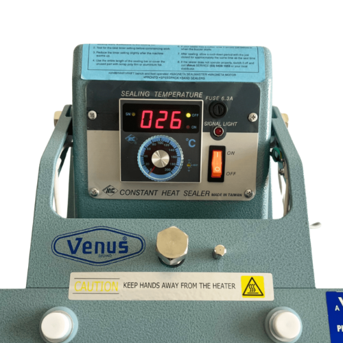Venus brand constant heat sealer machine with a digital temperature display showing 026 degrees Celsius, featuring a blue control panel, silver metal knobs, and a teal-gray metal body.