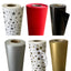 Continuous rolls of gift wrapping paper in various colors and designs, including plain red, black, silver, gold, and white with star patterns.