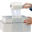 A roll of clear stretch wrap being applied to a box by a person.